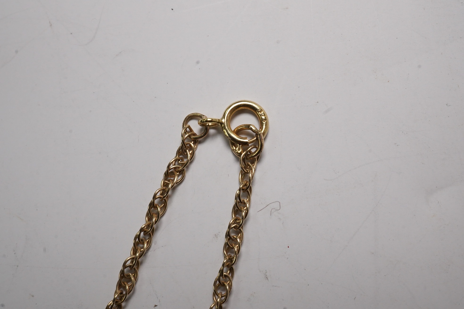 A yellow metal and diamond chip set fan shaped pendant, width 22mm, on a 375 chain, 40cm, gross 5.6 grams.